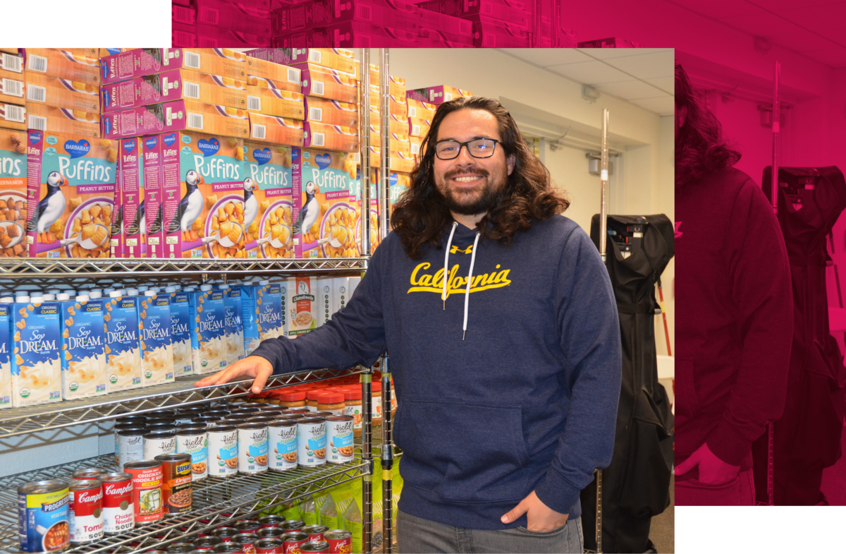 Ruben Canedo, UC System Basic Needs Co-Chair, posing in front of boxed and canned goods at the UC Berkeley Basic Needs Center