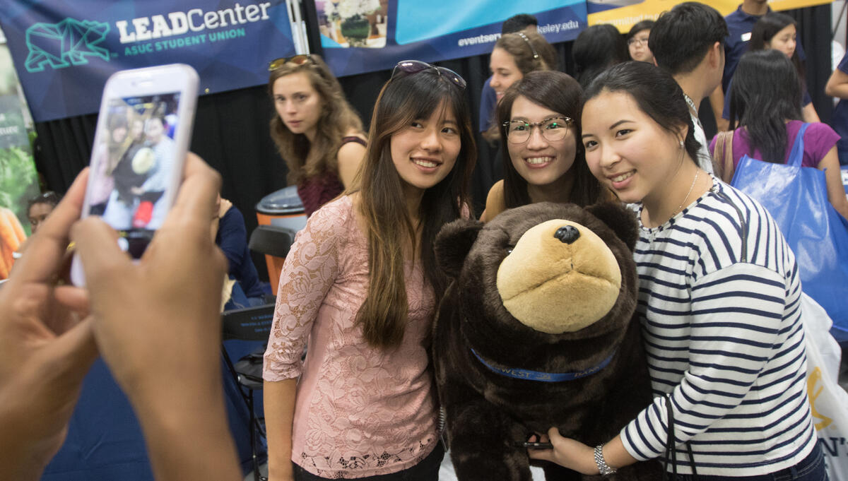 Students posing with a stuffed bear