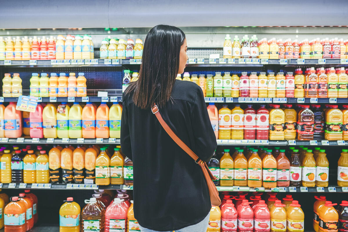 Woman standing in front of beverage aisle at the grocery store