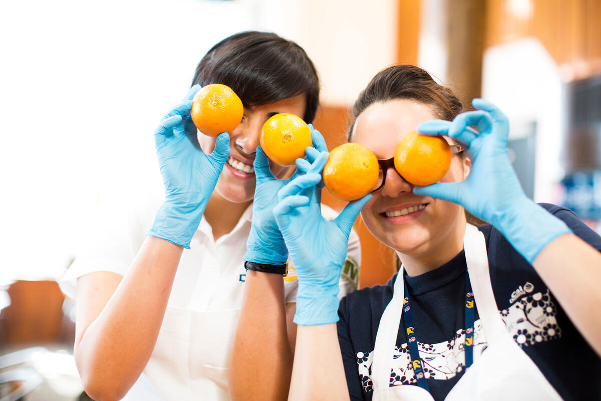 Oranges Photo of two dining employees holding oranges over their eyes