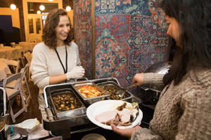 Volunteer assists student with buffet line