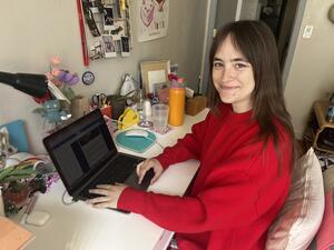Ava Richards sitting at desk working on a laptop