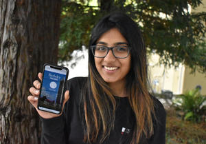 Berkeley student, Sruthi Machina, holds up her iphone showing the Berkeley Fitness Challenge app she worked on.